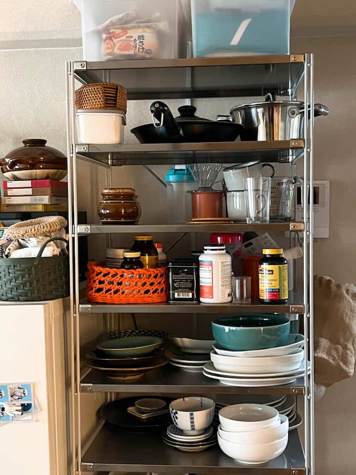 シルバーのメタルシェルフに多様な調理器具とボウルが収納された整ったキッチンスペース