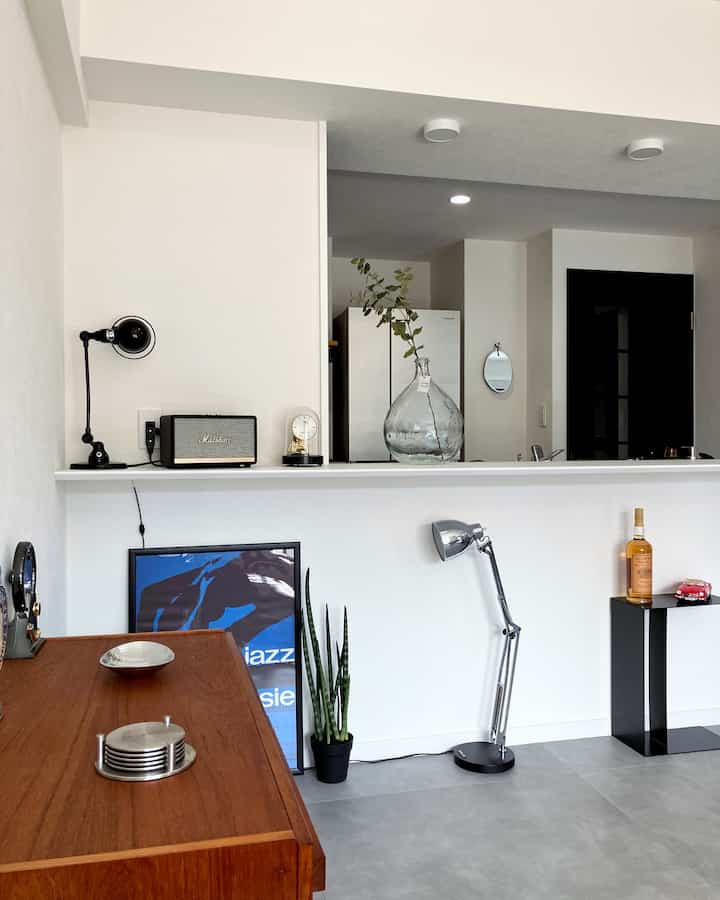 White and brown toned kitchen space featuring Mid-Century Modern wooden furniture and industrial lighting with a clean, stylish atmosphere