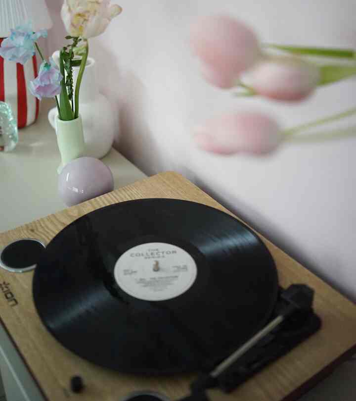 ナチュラルな木目調のレコードプレーヤーと花瓶が配置されたレトロな雰囲気のあるインテリア