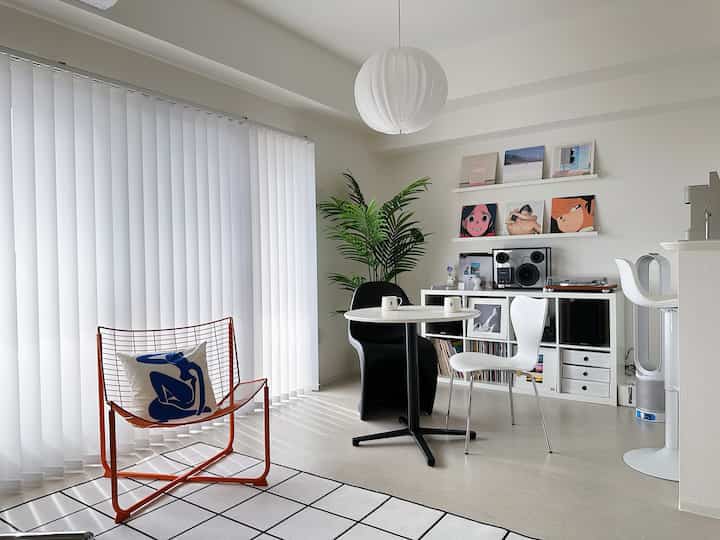 白を基調とした北欧風のリビング、シンプルな家具と大きな窓が配置された明るい空間