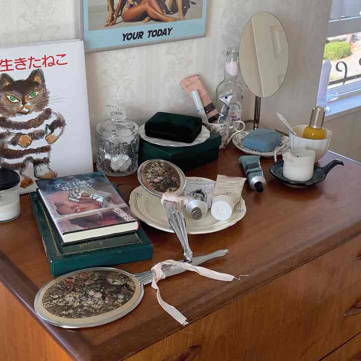木目調の化粧台に鏡と様々なビューティーアイテムが置かれたレトロな雰囲気のインテリア