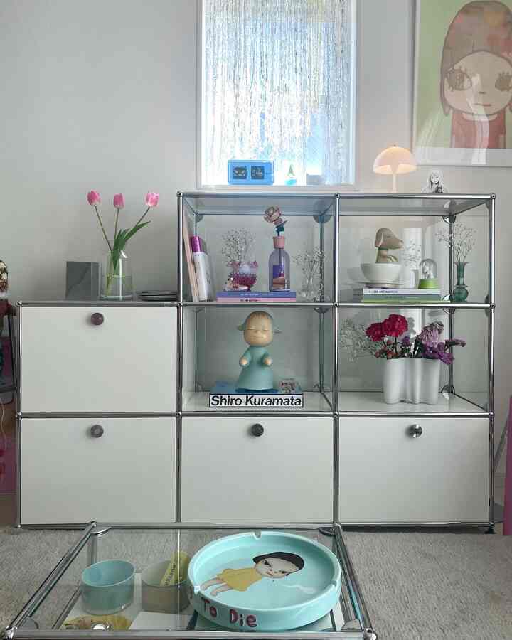 白を基調としたモダンなリビング、アートと花瓶が飾られた棚のある空間