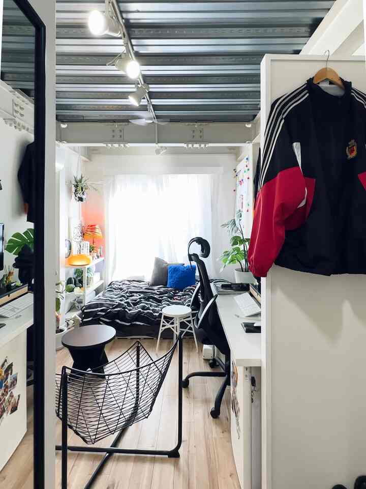 Bright white and wood-tone 6-tatami studio apartment featuring a desk and bed in a cozy single household space