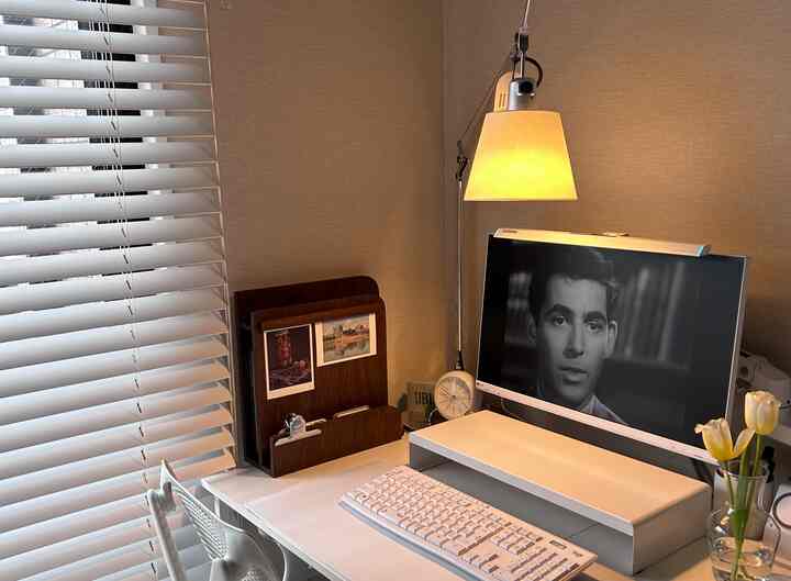 明るい木目調の壁と白い家具が配置されたコーナー型のホームオフィス空間