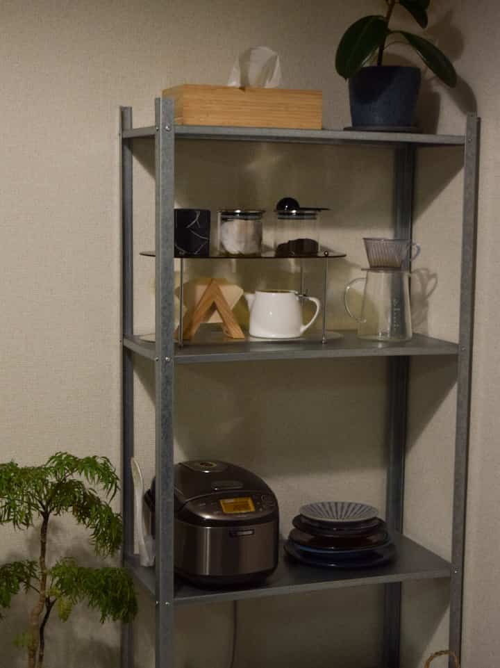 A neat home cafe space in a dining room with gray metal shelves and transparent glass containers arranged