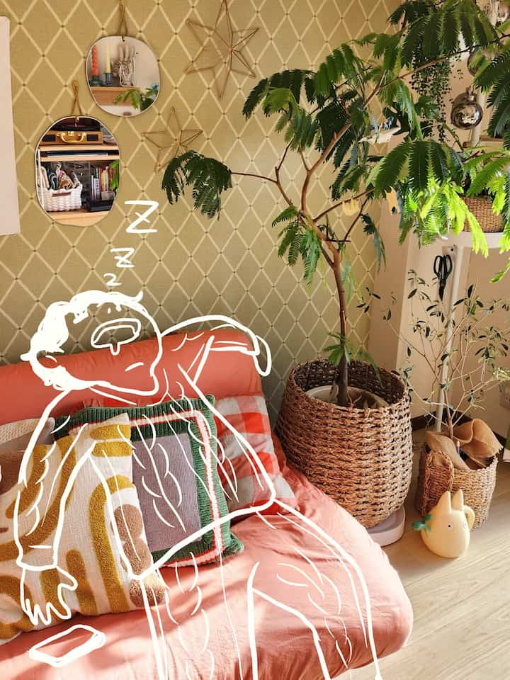 ナチュラルなベージュ色調の小さな部屋、ソファと大きな観葉植物が配置された落ち着いた空間