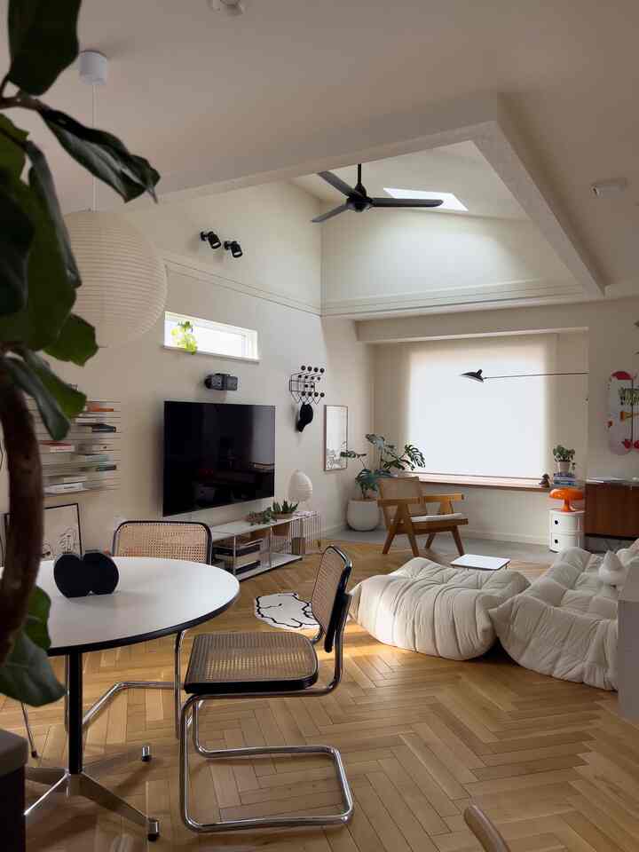 白とナチュラルカラーの二人用リビング、高い天井と多彩な照明が配された雰囲気のある空間