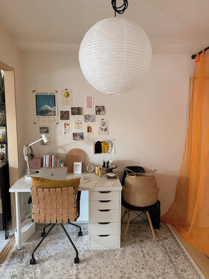 白とベージュのトーンのワークスペース、白いデスクと自然素材の椅子が配置された雰囲気のあるインテリア