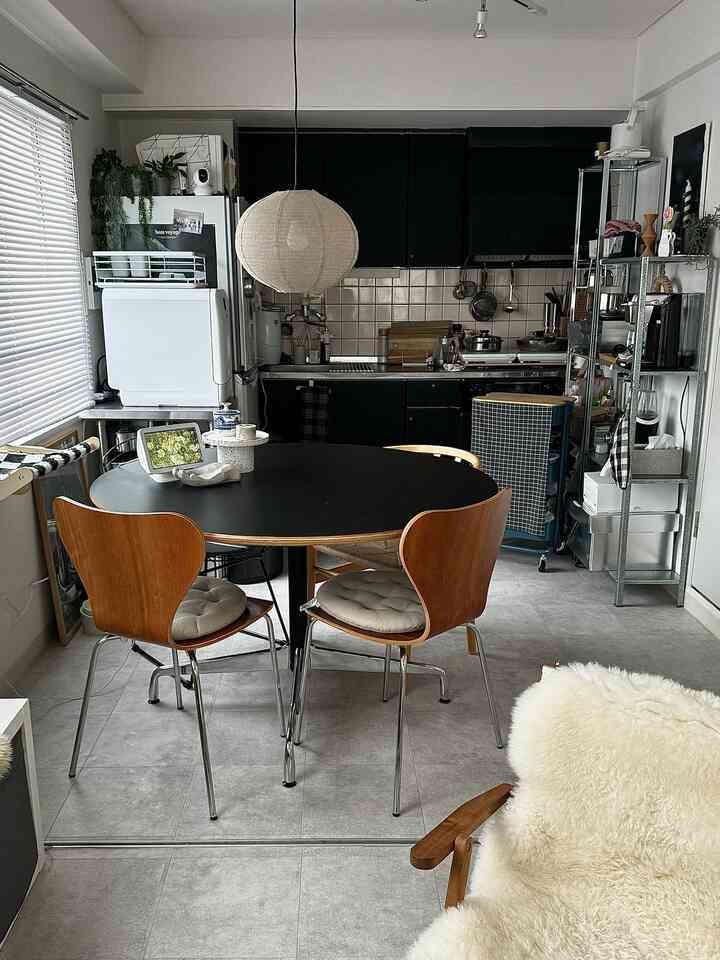 ブラックと木目調が調和した1LDKのキッチンとダイニング、シンプルでモダンな雰囲気のあるインテリア