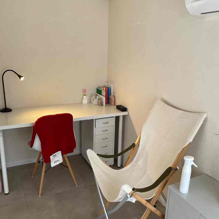 白とベージュのトーンのホームオフィス、シンプルなデスクとキャンプチェアが配置された落ち着いた書斎空間