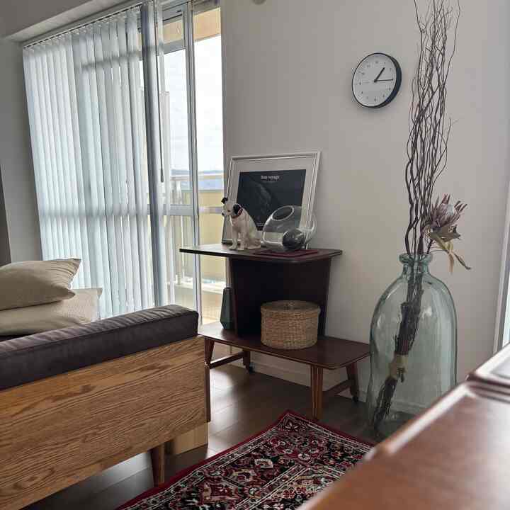 ナチュラルな木目調が映える白い壁とブラインドのある二人掛けリビング、温かみのある居心地良い空間