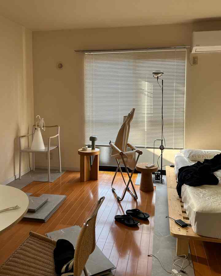 Natural tones and white blinds in a studio apartment featuring simple furniture arrangement and a clean, minimalist atmosphere