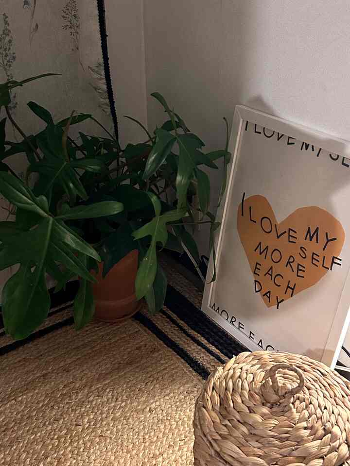 ナチュラルトーンの部屋の一角に、大きな観葉植物とジュートラグ、ラタンのアイテムが配置された雰囲気のあるインテリア