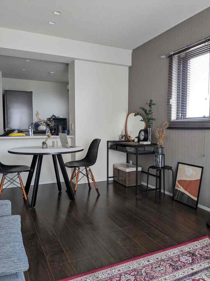 Modern dining room with white walls and black chairs, round dining table and natural wood-tone flooring create harmonious atmosphere
