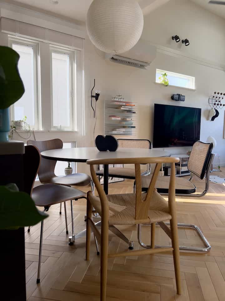 白と木目調の調和が美しいダイニングルーム、異なるデザインのダイニングチェアが配され、落ち着いたモダンな雰囲気のあるインテリア