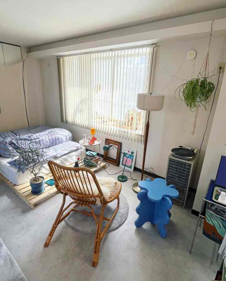 Natural color and gray toned bedroom featuring wooden chair, bed, and side table arranged cozily