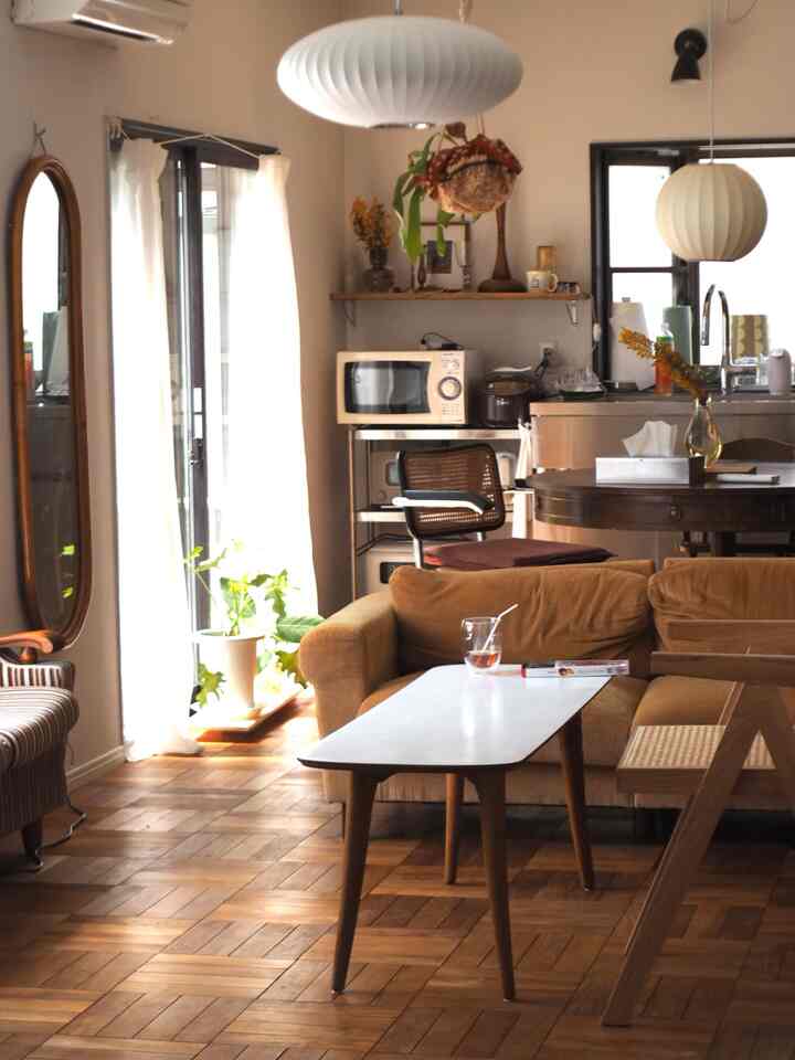 White and wood tone living and dining room featuring vintage furniture and natural materials in a cozy atmosphere