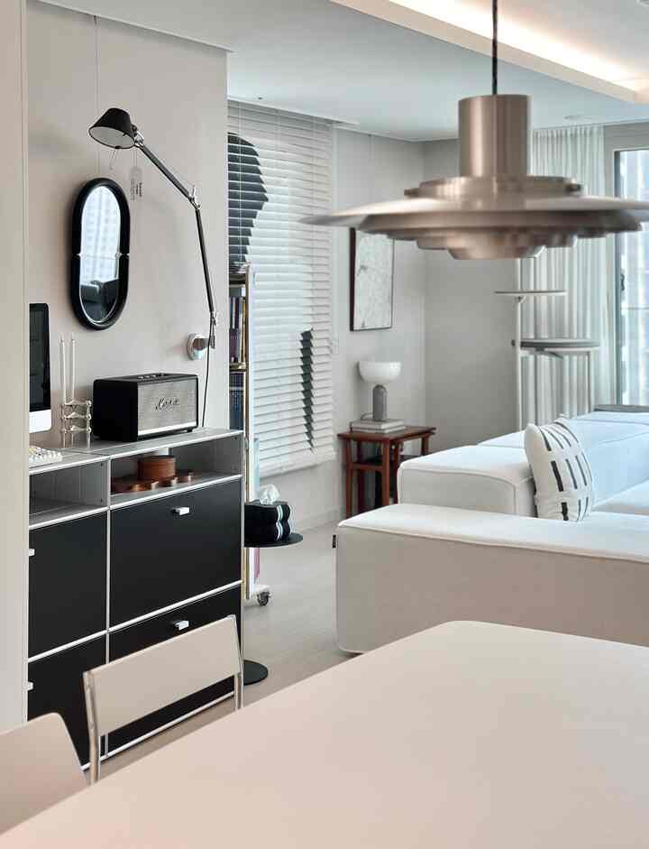 Black and white monotone living room featuring a large sofa and pendant light with a sleek, sophisticated atmosphere