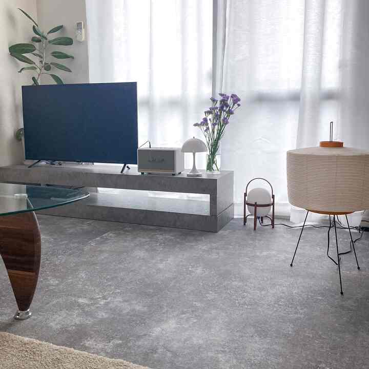 Monotone white-toned living room for a single household featuring a TV, minimalist furniture, and floor lamps with a simple atmosphere