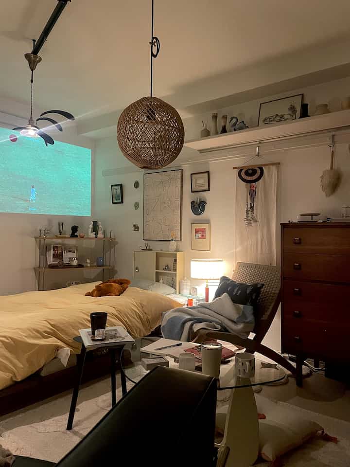 Natural-toned bedroom for a single household featuring beige bed, wooden furniture, warm lighting, and Nordic style decor