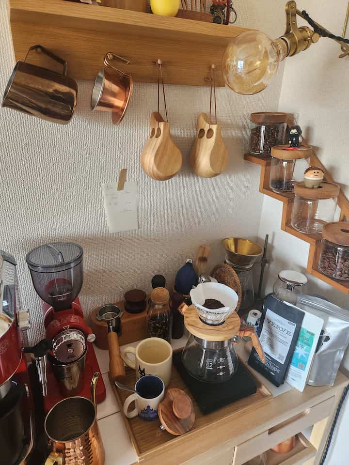 ナチュラルな木目調のキッチンコーナーにコーヒードリップ道具とコーヒー豆が整然と配置された雰囲気のあるおうちカフェ