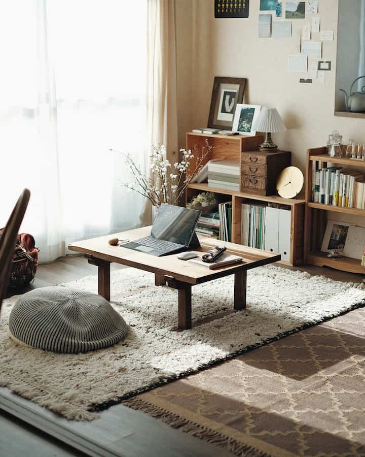 Natural color living room featuring a low table, cushion, and bookshelves creating a cozy atmosphere