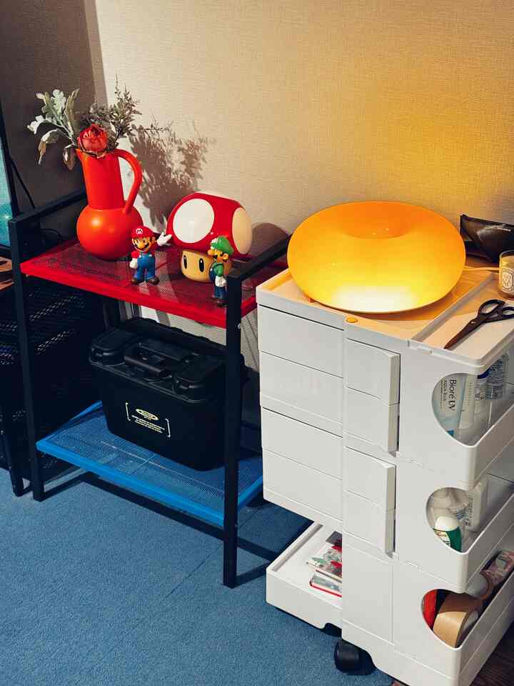 A neat space featuring red and white tones with a storage shelf and wheeled storage cart arranged neatly