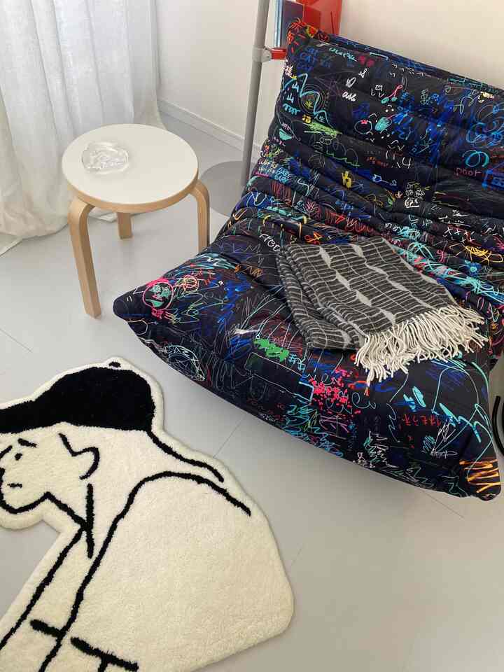 白い床とカラフルなトーゴ柄のソファが配置されたミッドセンチュリーモダンのリビング空間