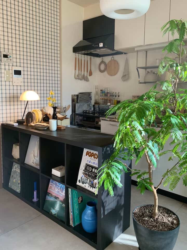 黒い棚ユニットとキッチン用品が並ぶ、ナチュラルでモダンなキッチンのインテリア