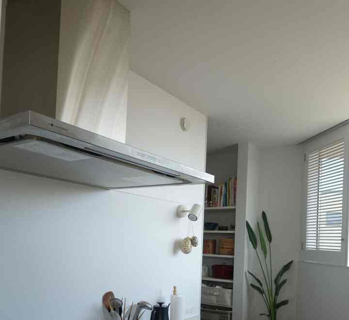 白を基調としたキッチン、シンプルで自然素材の小物が配置された雰囲気のあるインテリア