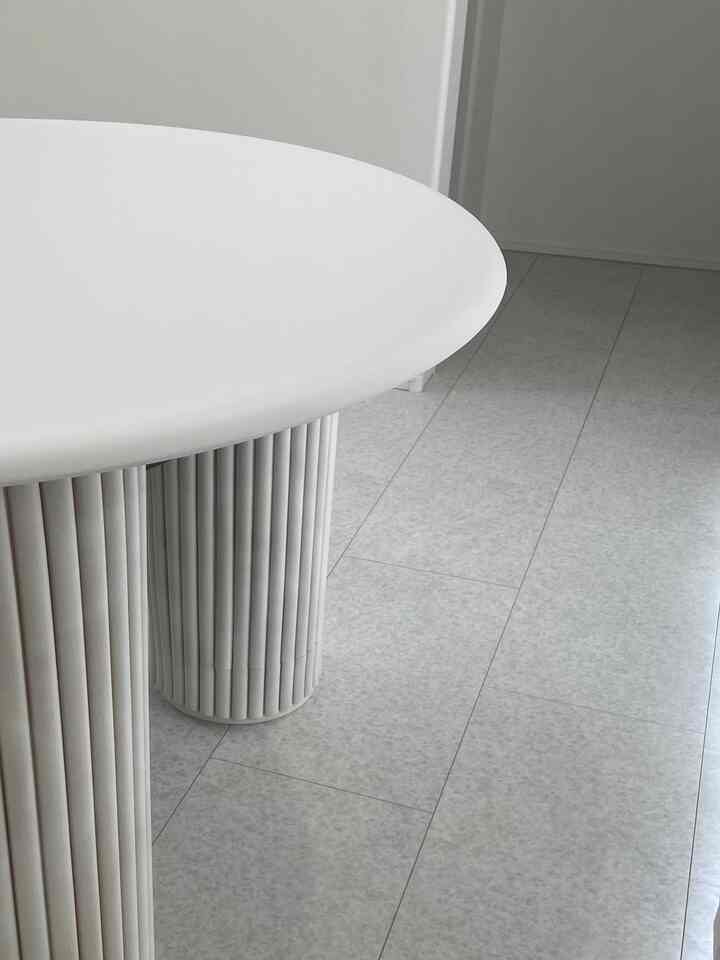 モノトーンと白色が調和したダイニング空間、ラウンドテーブルとタイル床が清潔感のある雰囲気を演出