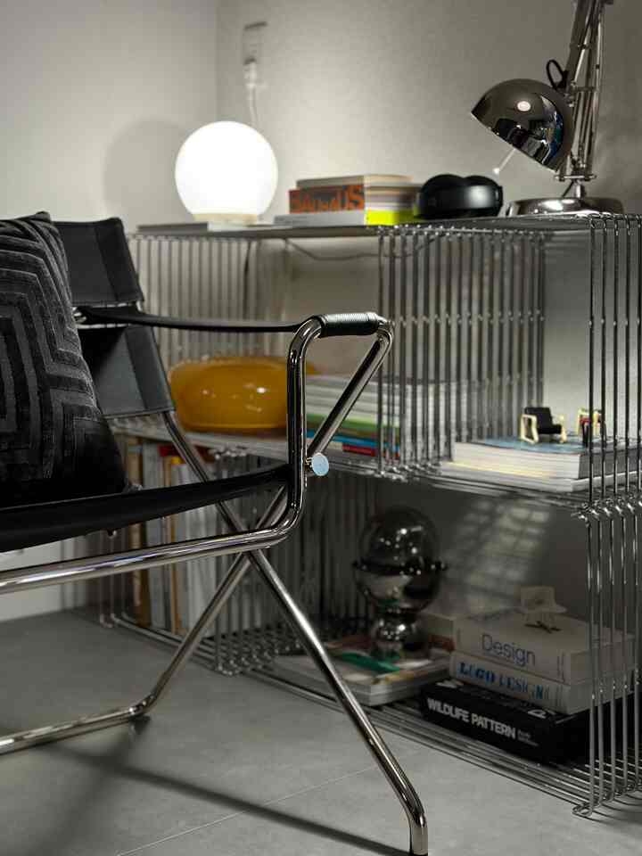Black and silver toned home office space featuring a metal wire-frame desk and modern chair with a simple interior