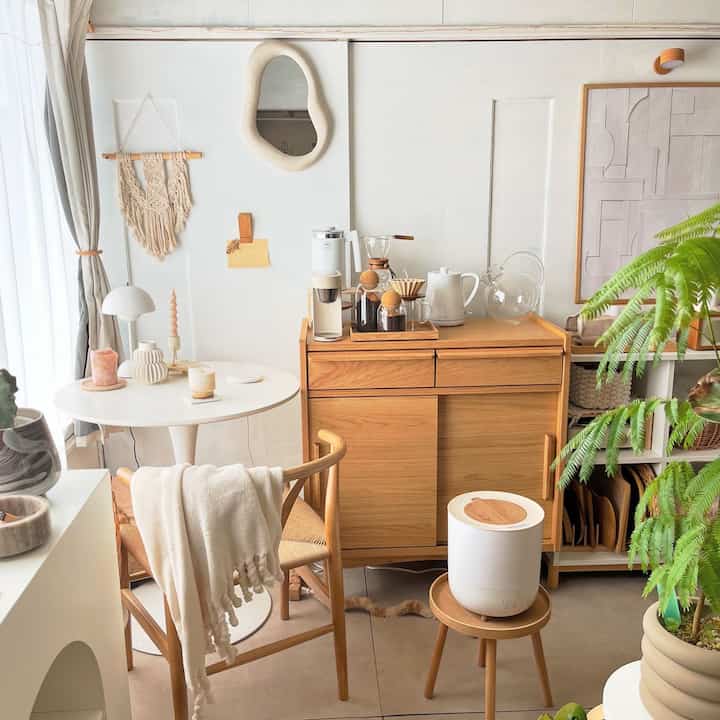 ナチュラルカラーと木目調が調和したおうちカフェ空間、木製キャビネットとテーブル、植物が配置された温かみのあるインテリア