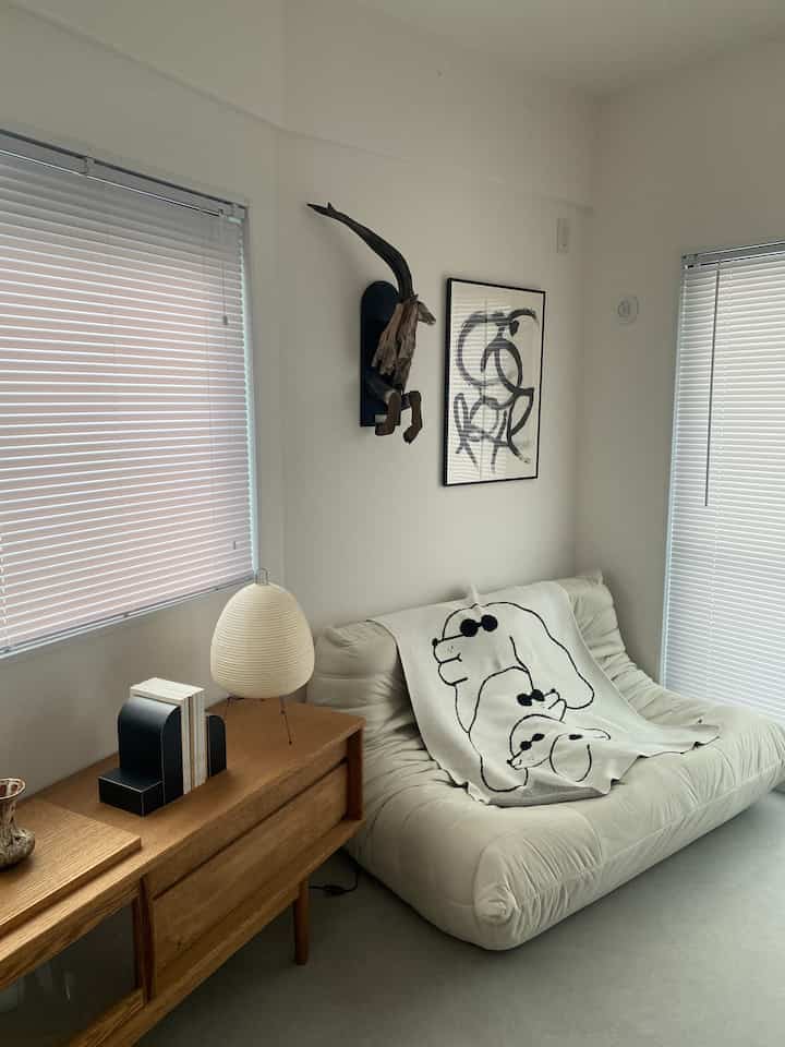 明るいホワイトと木目調が調和する和モダンスタイルのウォークインクローゼット、快適なソファとアートが配置された印象的な空間