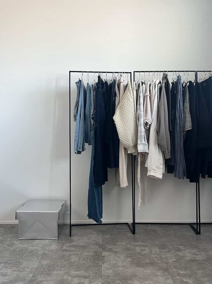 Simple space with black iron hanger racks against white walls featuring clever storage ideas