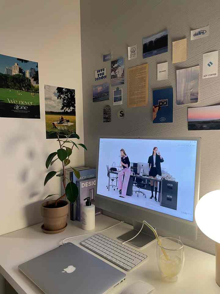 ホワイトトーンのコンパクトなホームオフィス、ポスターと植物が配置されたシンプルなインテリア