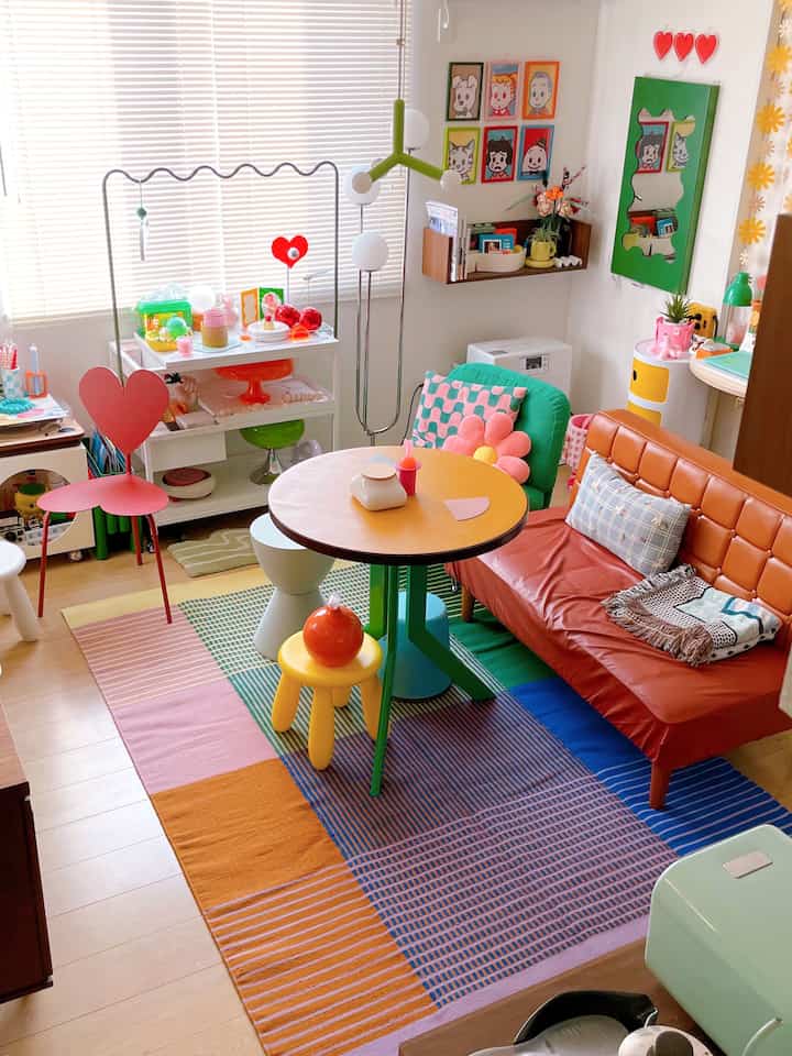 A multicolored rug and orange sofa in a living room with lively decorative accents
