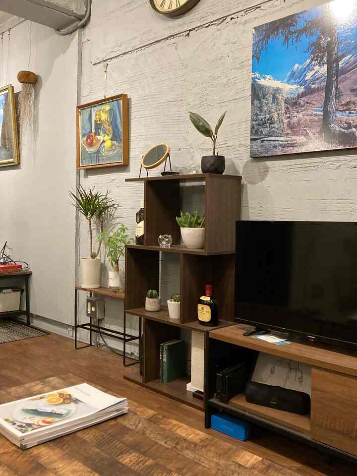 Warm brown wood-tone living room featuring open shelving and TV stand in a natural, simple setting