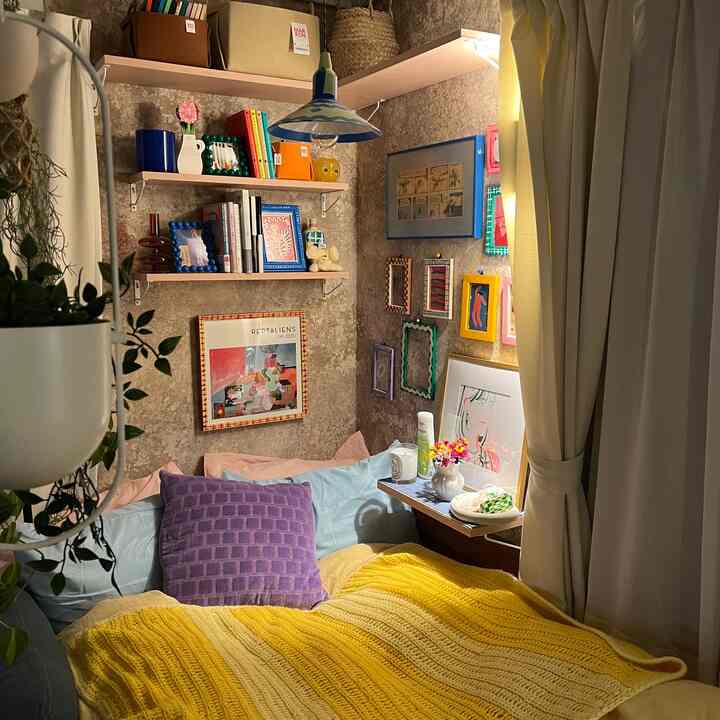 Cozy natural-toned bedroom featuring a yellow knit blanket and colorful picture frames