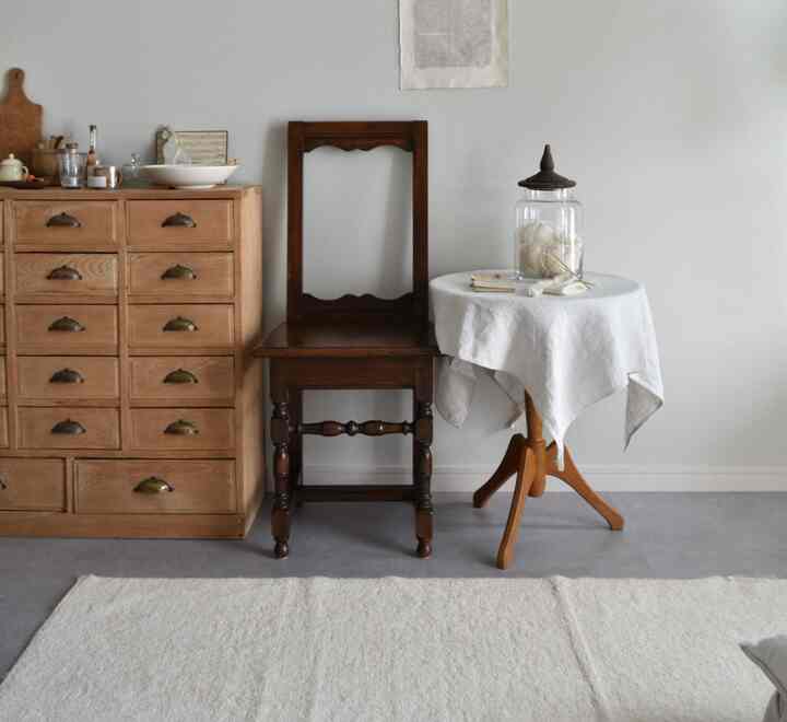 Simple vintage living space featuring brown wood tone furniture with white textile accents