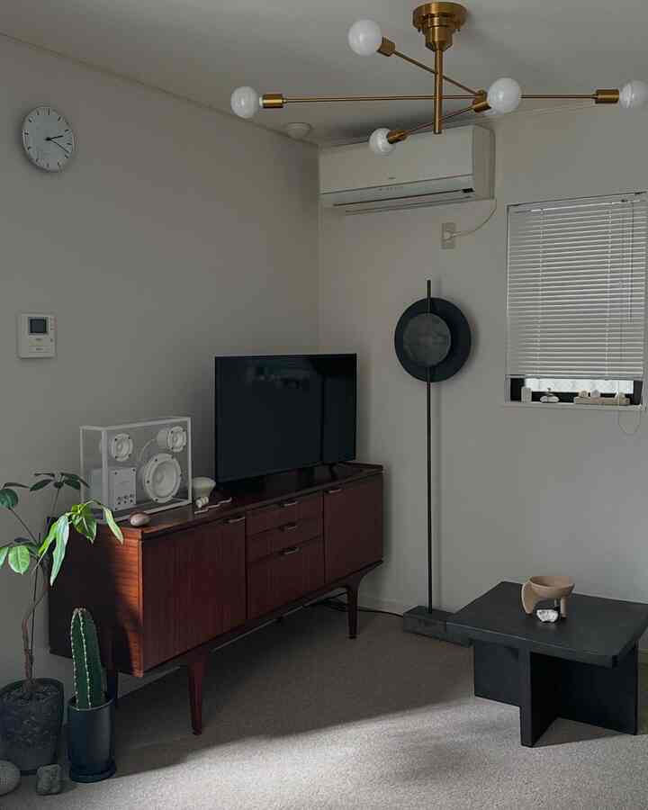 落ち着いたブラウンとグレーの色調のリビング、レトロ風家具とシンプルな照明が配置された雰囲気のあるインテリア