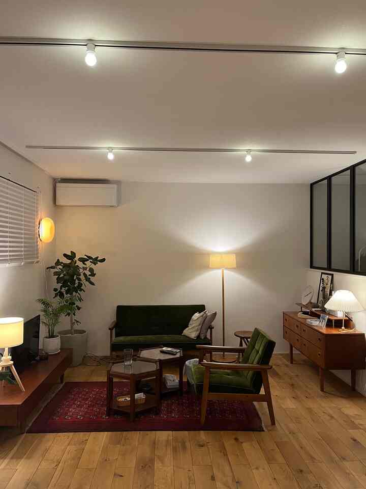 ブラウンの木目調とグリーンのソファが配置されたナチュラルモダンな雰囲気のリビング