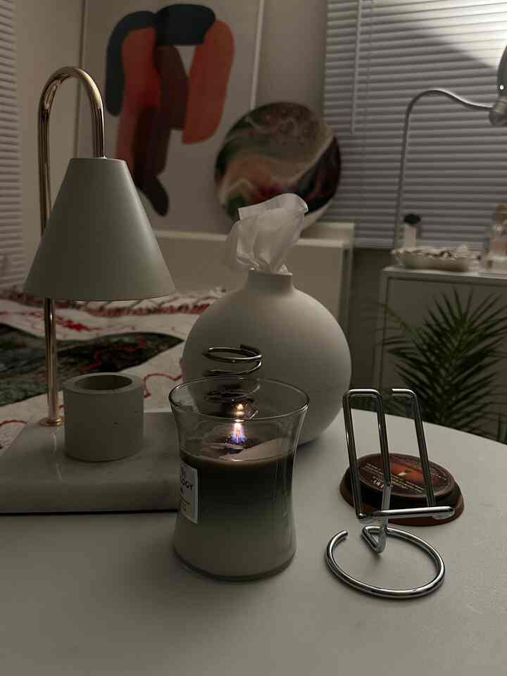 ホワイトとシルバーのトーンが特徴のミニマルなホームオフィスデスク、テーブルランプとティッシュケースが置かれた落ち着いた空間