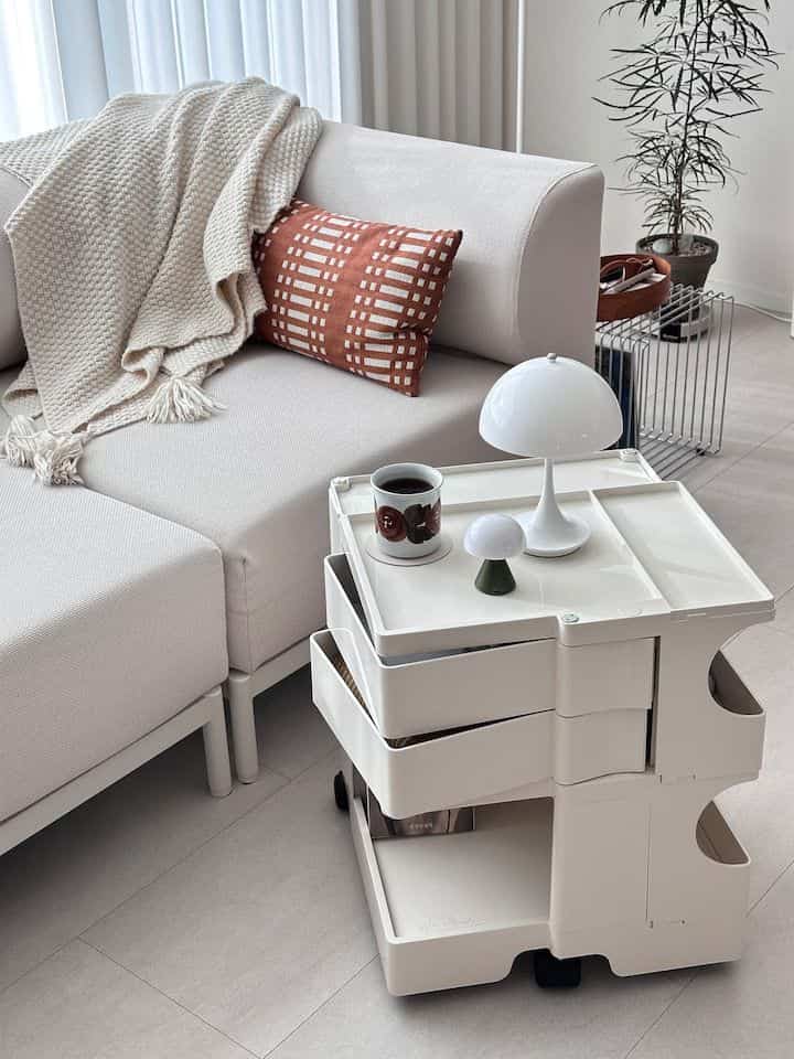 Beige and ivory-toned single household space featuring sofa and multi-purpose trolley creating a cozy home cafe vibe.