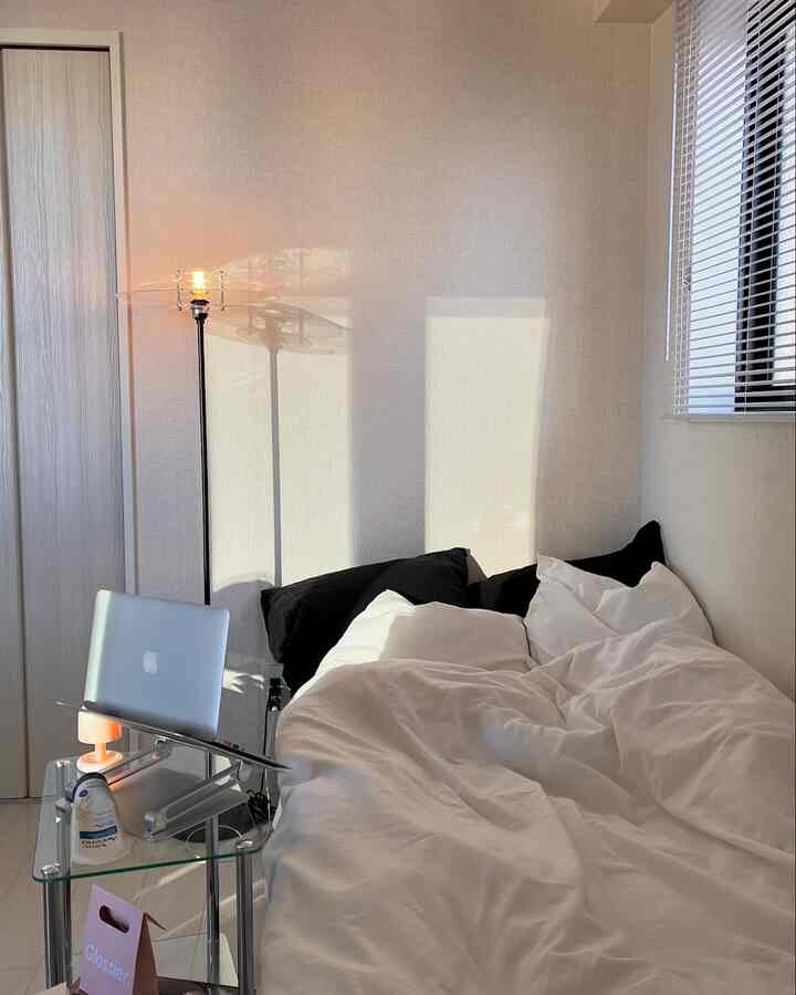 白と黒のトーンの寝室、ベッドとコンパクトなホームオフィスが配置された清潔な空間