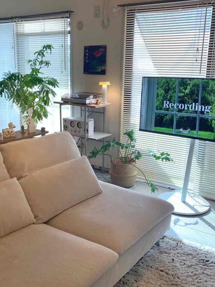 ナチュラルカラーのリビングルーム、ベージュのソファとブラインドが配置された雰囲気のある空間