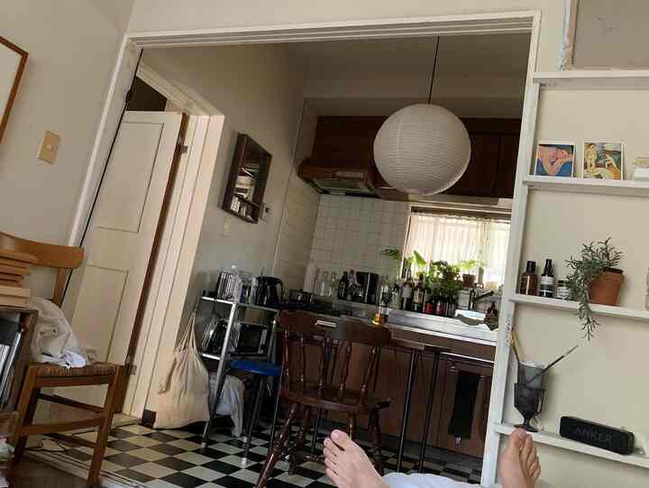 White walls and brown wooden furniture define a cozy vintage apartment kitchen and dining room space