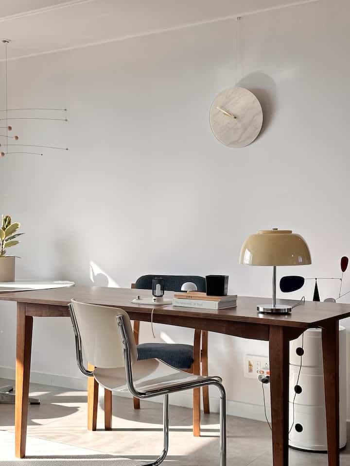 Bright white-wall natural dining room featuring wood-tone table and simple modern elements