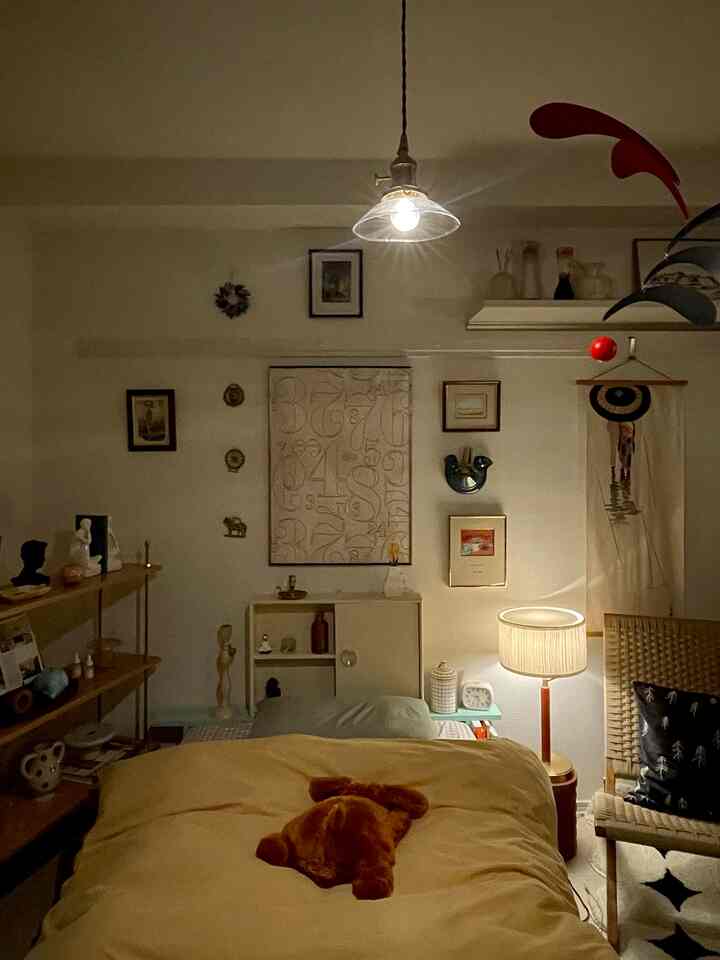 暖かい黄色調の寝室、自然な木製家具とラタンチェアが印象的な雰囲気をつくる空間