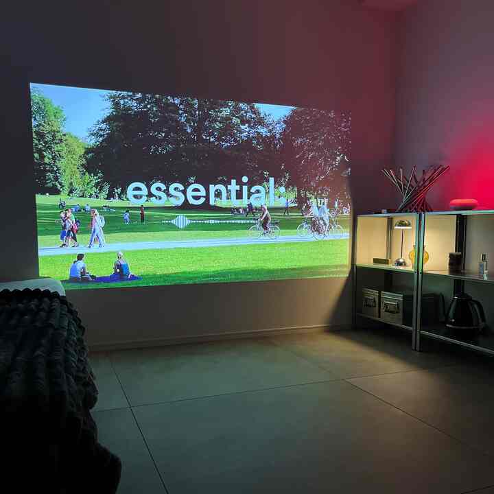 暗めのトーンの7畳ワンルーム、壁にプロジェクター映像が映るシンプルでモダンなインテリア